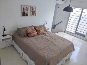 a bedroom with a large bed with two pillows at Hermoso departamento dos pisos bajo de San Isidro in San Isidro