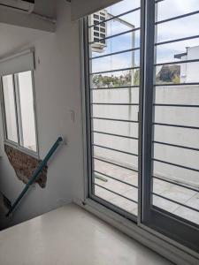 a room with a large window and an umbrella at Hermoso departamento dos pisos bajo de San Isidro in San Isidro