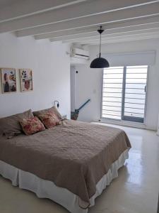 a bedroom with a bed and a large window at Hermoso departamento dos pisos bajo de San Isidro in San Isidro