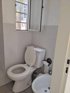 a bathroom with a toilet and a sink and a window at Hermoso departamento dos pisos bajo de San Isidro in San Isidro