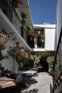 un patio al aire libre con mesas, sillas y plantas en HOLT Hotel del Pueblito en San Miguel de Allende