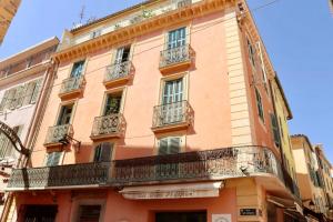 an orange building with balconies on a street at Appartement centre historique, idéal couple in Hyères