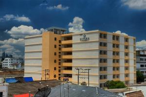 a large white building with a sign on it at Sitara Place Serviced Apartment & Hotel in Bangkok