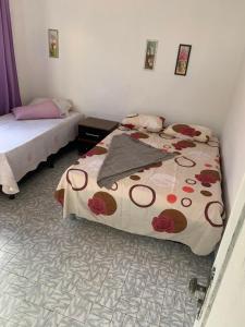 a bedroom with two beds with flowers on it at Pousada Tropical in Marataizes