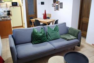 努斯的住宿－Maisonette，客厅里配有带绿色枕头的蓝色沙发
