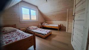een zolderkamer met 2 bedden en een raam bij Domki na polanie in Roztoki