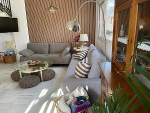 uma sala de estar com um sofá e uma mesa em El Jardin de la Palmera em Sevilha