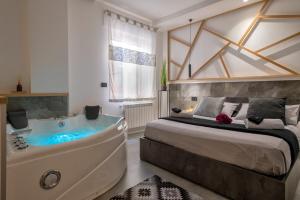 1 dormitorio con 1 cama grande y bañera en saige holidays en Alghero