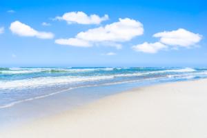 una spiaggia con l'oceano e le nuvole nel cielo di Ostseeklang a Zingst