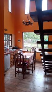 cocina con mesa, sillas y ventana en Casa de campo El Ceibal en Salta