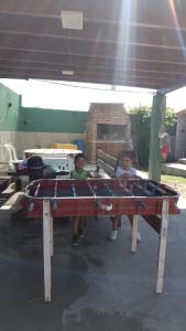 two children sitting on a picnic table under awning at Casa de campo El Ceibal in Salta