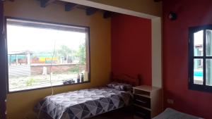 a bedroom with a bed and a large window at Casa de campo El Ceibal in Salta