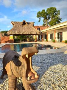 a statue of an elephant with a hat in front of a building at finca campestre las heliconias in Puerto Triunfo