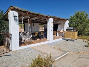 eine Terrasse mit einem Tisch, Stühlen und einem Grill in der Unterkunft Casa De La Familia - Casa Rural in Baza