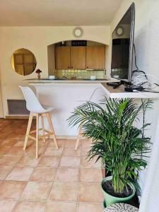 cocina con encimera, 2 sillas y mesa en Chic Studio Climatisé avec Parking 5mn plage, en Saint-Tropez