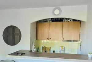 - une cuisine avec des placards en bois et un comptoir dans l'établissement Chic Studio Climatisé avec Parking 5mn plage, à Saint-Tropez