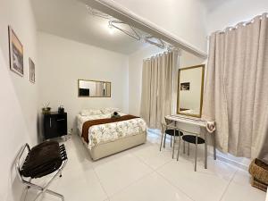 - une chambre avec un lit, un bureau et un miroir dans l'établissement Studio'S Bartho Leblon, à Rio de Janeiro