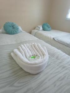 two beds with a white towel on top of them at Cabañas Aliwen in Ñilque