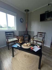 a living room with a table and a fireplace at Cabañas Aliwen in Ñilque