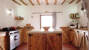 eine Küche mit Holzschränken und einer weißen Arbeitsplatte in der Unterkunft Casa De La Familia - Casa Rural in Baza