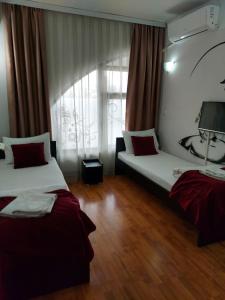 a hotel room with two beds and a window at The Bulevard Hotel in Skopje