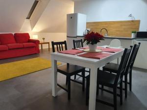 stół i krzesła w kuchni z czerwoną kanapą w obiekcie Nový podkrovný byt v rodinnom dome (5 osôb) w mieście Nowe Miasto nad Wagiem
