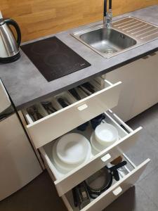 - une cuisine avec évier et vaisselle blanche dans un tiroir dans l'établissement Nový podkrovný byt v rodinnom dome (5 osôb), à Nové Mesto nad Váhom