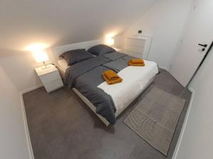 1 dormitorio con 1 cama grande y 2 toallas. en Nový podkrovný byt v rodinnom dome (5 osôb), en Nové Mesto nad Váhom