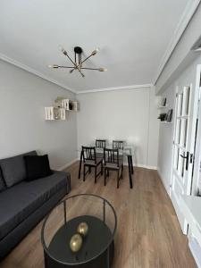 een woonkamer met een bank en een tafel bij Piso acogedor cerca del centro. in Burgos