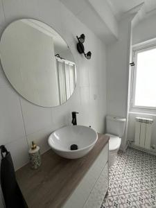 een witte badkamer met een wastafel en een spiegel bij Piso acogedor cerca del centro. in Burgos