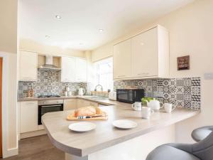 a kitchen with a wooden table with plates on it at 3 bed in Conwy 87866 in Penmaen-mawr