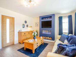 a living room with a couch and a tv at 3 bed in Conwy 87866 in Penmaen-mawr
