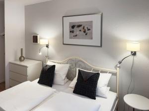 a bedroom with two beds with white sheets and pillows at Ferienwohnung Tidenblick in Wittdün