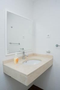 a bathroom sink with a mirror and a soap bottle on it at Villa Santiago in Praia