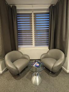 two chairs and a table in front of a window at Hotel 33 in Blackpool +36 photos