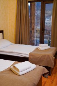 two beds in a room with towels sitting on them at Royal Rest Townhouse in Dilijan