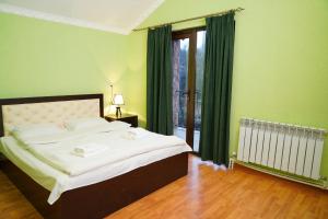 a bedroom with a large bed and a window at Royal Rest Townhouse in Dilijan