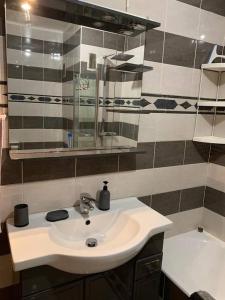 ein Badezimmer mit einem weißen Waschbecken und einer Badewanne in der Unterkunft Appartement à 50 mètres de la plage in Cagnes-sur-Mer