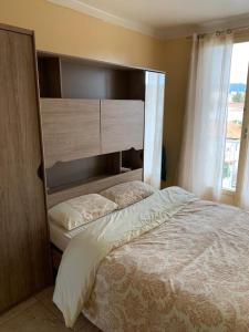 um quarto com uma cama grande e uma janela grande em Appartement à 50 mètres de la plage em Cagnes-sur-Mer