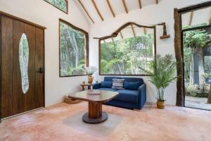 a living room with a blue couch and a table at Casa de la Selva-Jungle Getaway with cenotes in Playa del Carmen