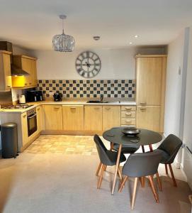 een keuken met een tafel en stoelen in een kamer bij City Centre apartment. in Wrexham