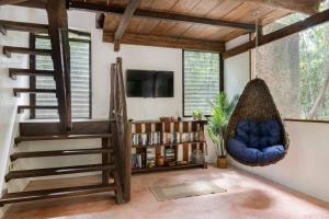 a living room with a staircase and a tv at Casa de la Selva-Jungle Getaway with cenotes in Playa del Carmen
