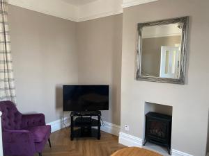 a living room with a television and a mirror at Ballea Farmhouse in Cork