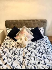 a bed with black and white sheets and pillows at City Centre apartment. in Wrexham