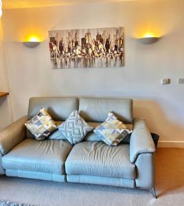 a couch in a living room with a painting on the wall at City Centre apartment. in Wrexham