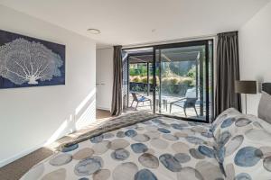a bedroom with a bed and a view of a patio at Noir South Retreat in Wanaka