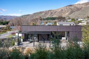 a modern house with mountains in the background at Noir South Retreat in Wanaka