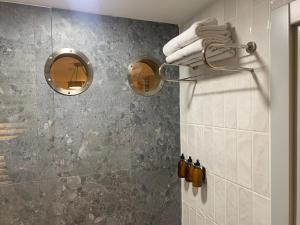 a bathroom with a shower with two mirrors at Deluxe Apartment at the seaside in Pasaport Alsancak Izmir in Konak