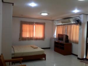 a bedroom with a bed and a tv and curtains at J Hotel2 in Ao Nang Beach