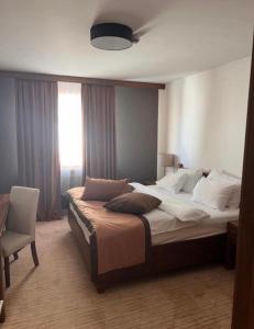 - une chambre avec un grand lit et une chaise dans l'établissement Apartment B327 Aparthotel Vucko, à Jahorina